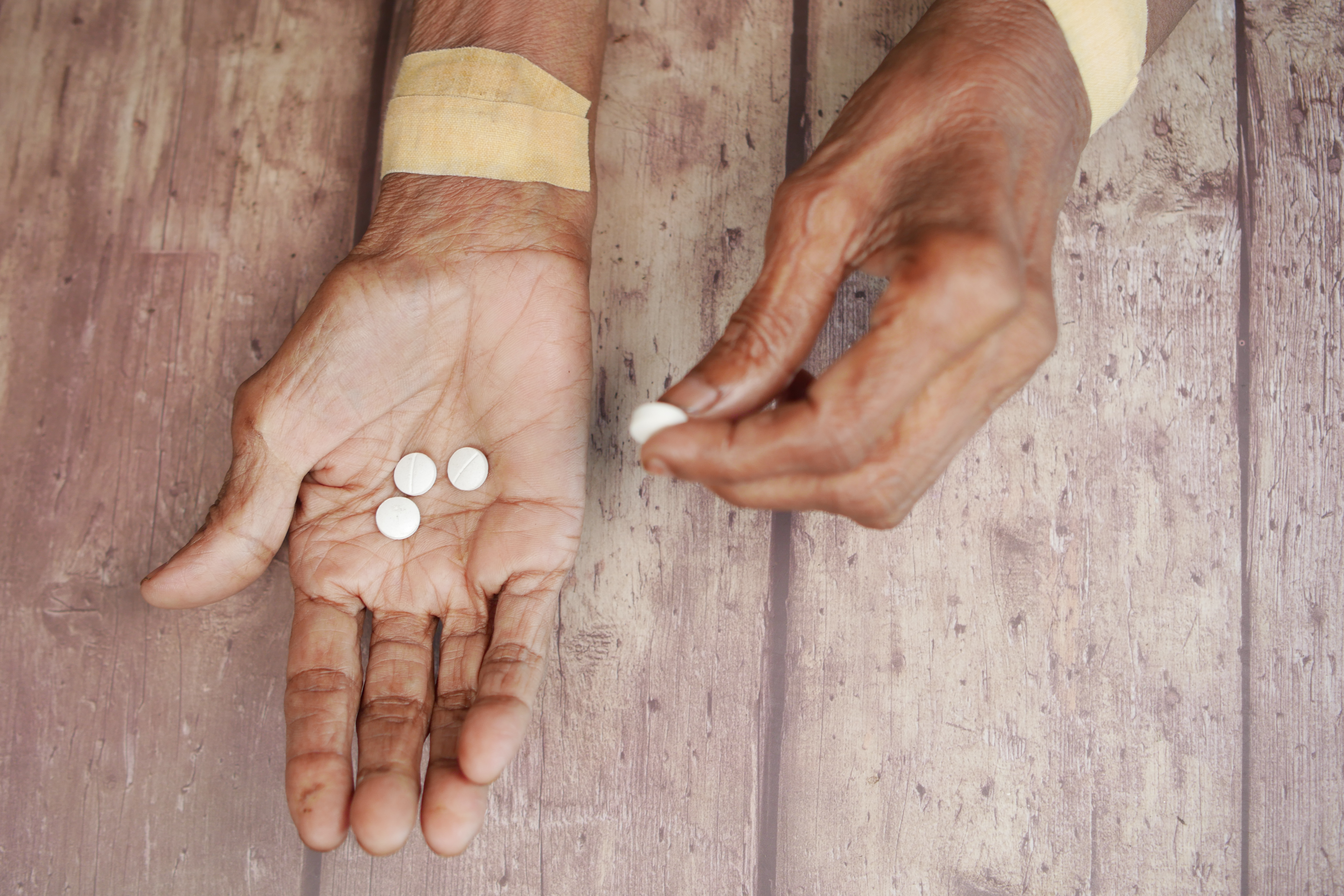top view of senior women taking pills .