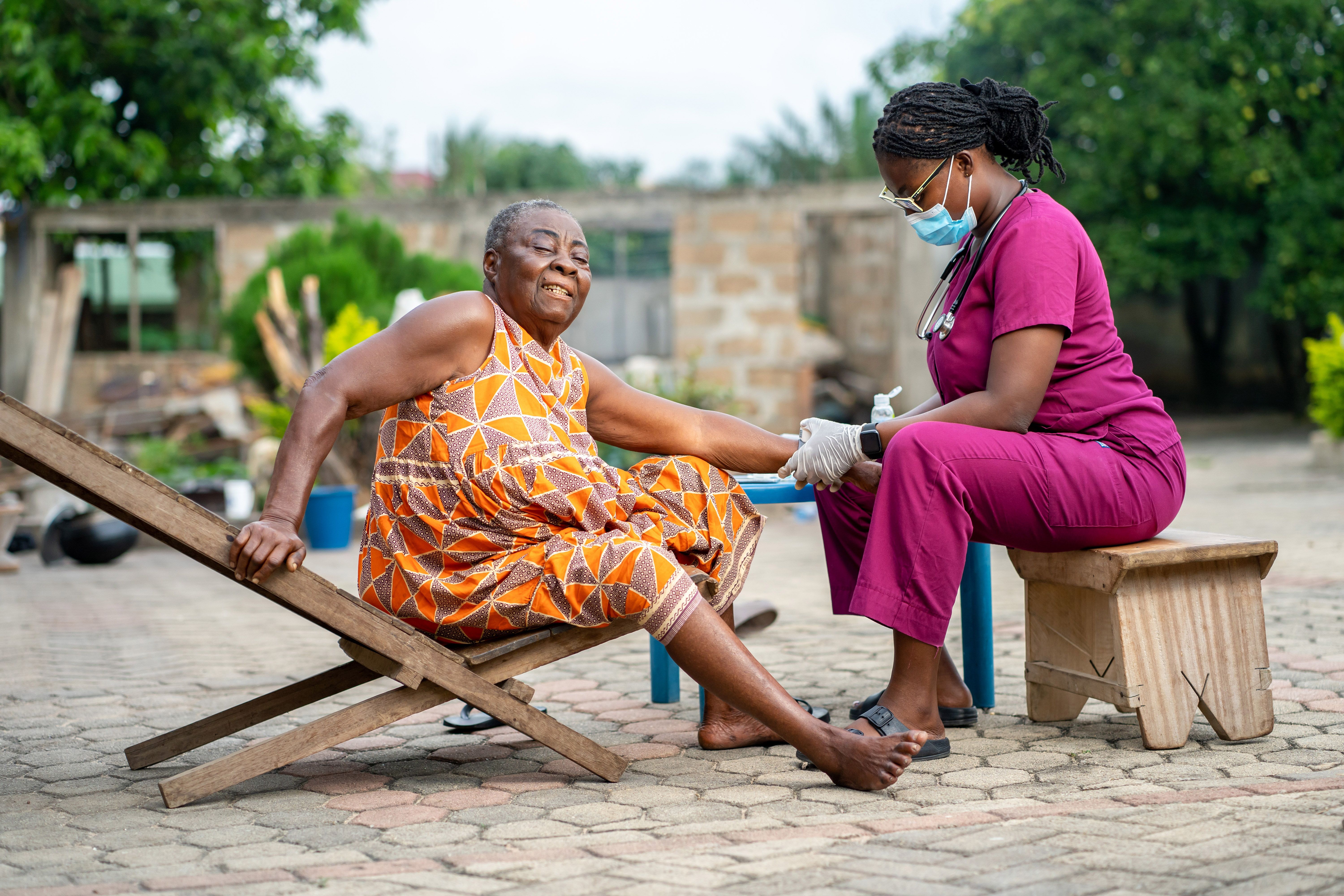 A young African nurse with a patient in a home care service.